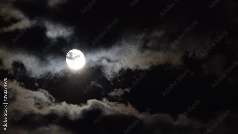 Dark night black sky clouds moving across full moon