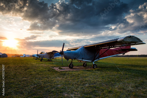Small private airplanes parked at the airfield at picturesque sunset