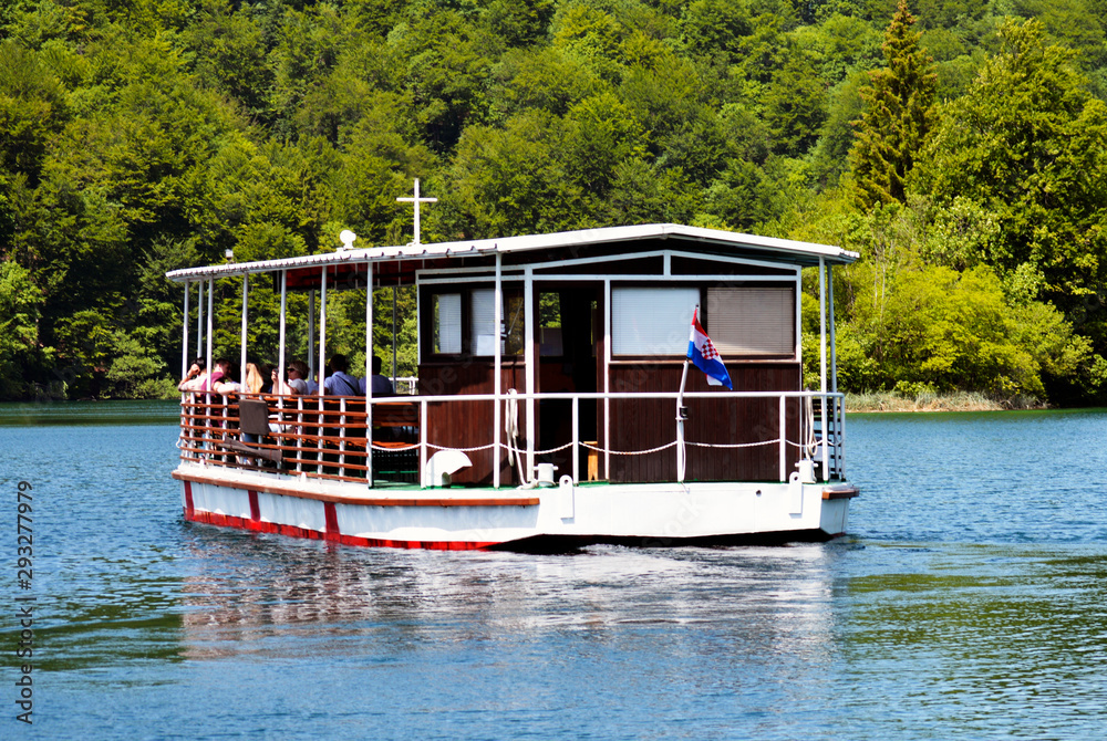 Electrical boat with tourists on the crystal clear and pure water of Lake Kozjak, Plitvice Lakes National Park, Croatia Electrical boat with tourists on the crystal clear and pure water of Lake Kozjak, Plitvice Lakes National Park, Croatia