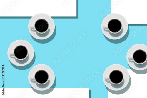 Cups with coffee on aquamarine background. Free space. Sheets of white paper. Top view.