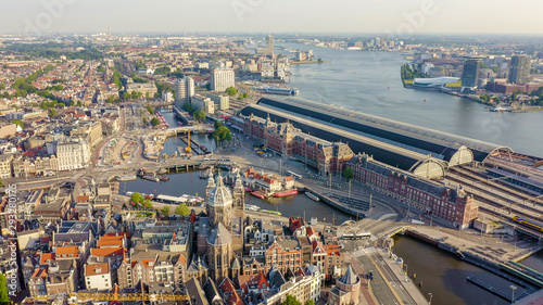 Amsterdam, Netherlands. Flying over the city rooftops.  Amsterdam Central Station ( Amsterdam Centraal ), Aerial View