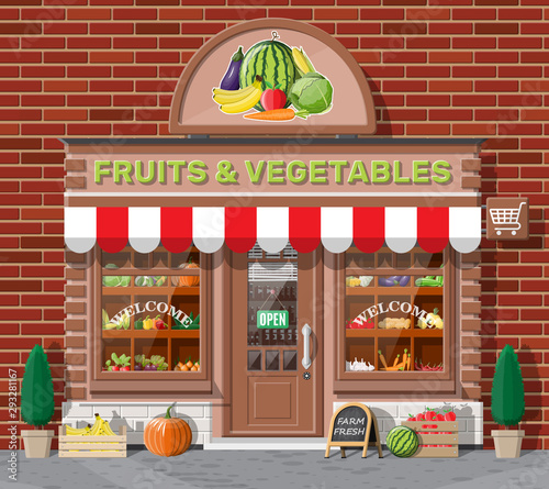 Street brick shop building exterior. Fruit and vegetable store facade. Fresh organic food products. Cucumber tomato pumpkin garlic onion carrot corn pepper banana. Vector illustration in flat style