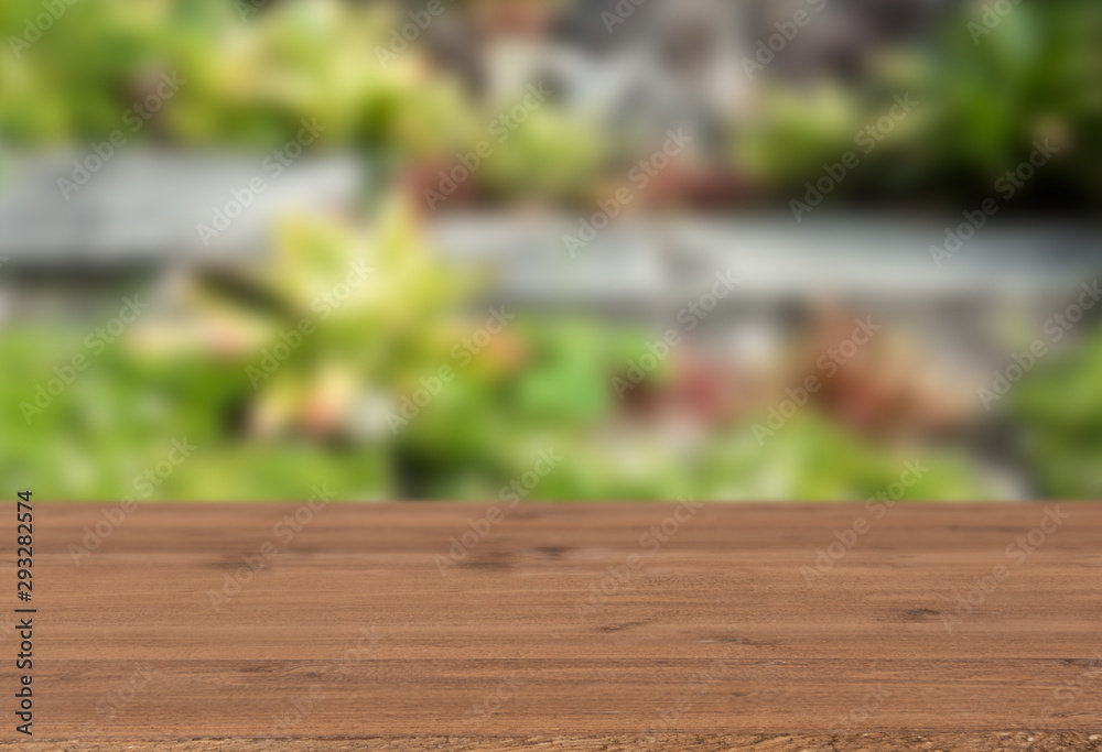 Brown wood table top with fresh green garden outdoors  background