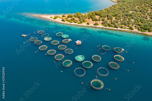 Aerial view of a slide from a drone on a beautiful panorama of the sea and mountains on the island. Fish farm by the sea in Greece. Fish breeders in natural marine waters. View the island in the sea