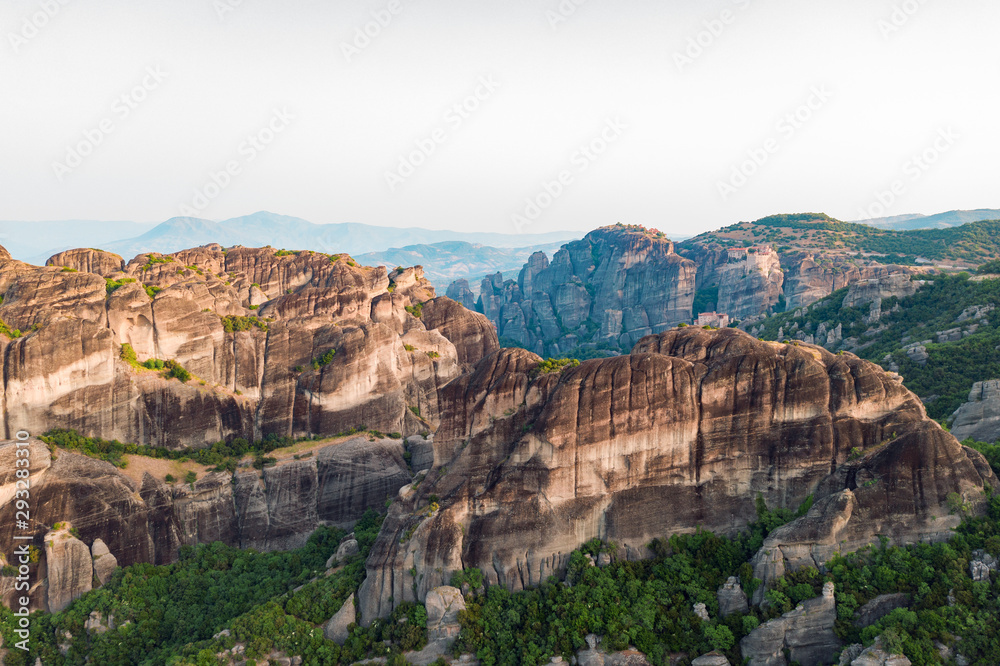 Aerial view of a slide from a drone on a panorama of a mountain range. Kalampaka city, Greece. View of the cliffs of Meteora and the monasteries of Meteora. Many ancient Orthodox monasteries
