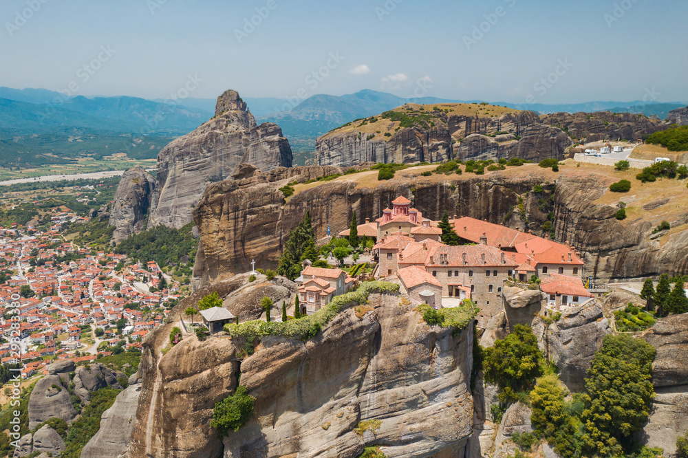 Aerial view of a slide from a drone on a panorama of a mountain range. Kalampaka city, Greece. View of the cliffs of Meteora and the monasteries of Meteora. Many ancient Orthodox monasteries summer
