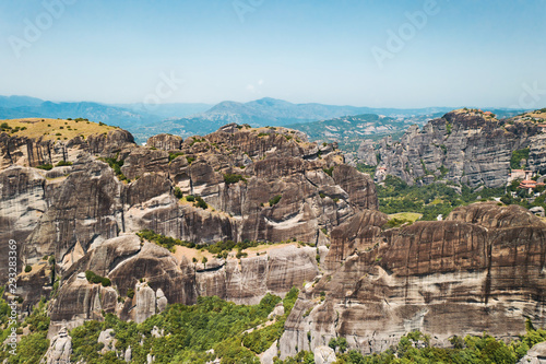 Aerial view of a slide from a drone on a panorama of a mountain range. Kalampaka city, Greece. View of the cliffs of Meteora and the monasteries of Meteora. Many ancient Orthodox monasteries summer