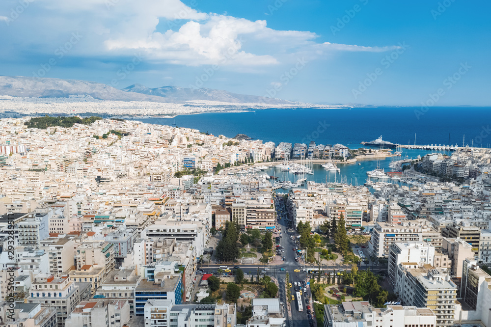 Piraeus, Greece aerial view drone on panorama of buildings of residential and administrative buildings of the city in summer on sunny day. Roof plan aerial view of the blue sea. Front view