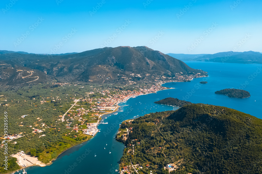 Aerial view from a drone on a panorama of the blue sea, picturesque islands and mountains in Greece, in summer on a sunny day. Beautiful coastline of the resort town. Tourism