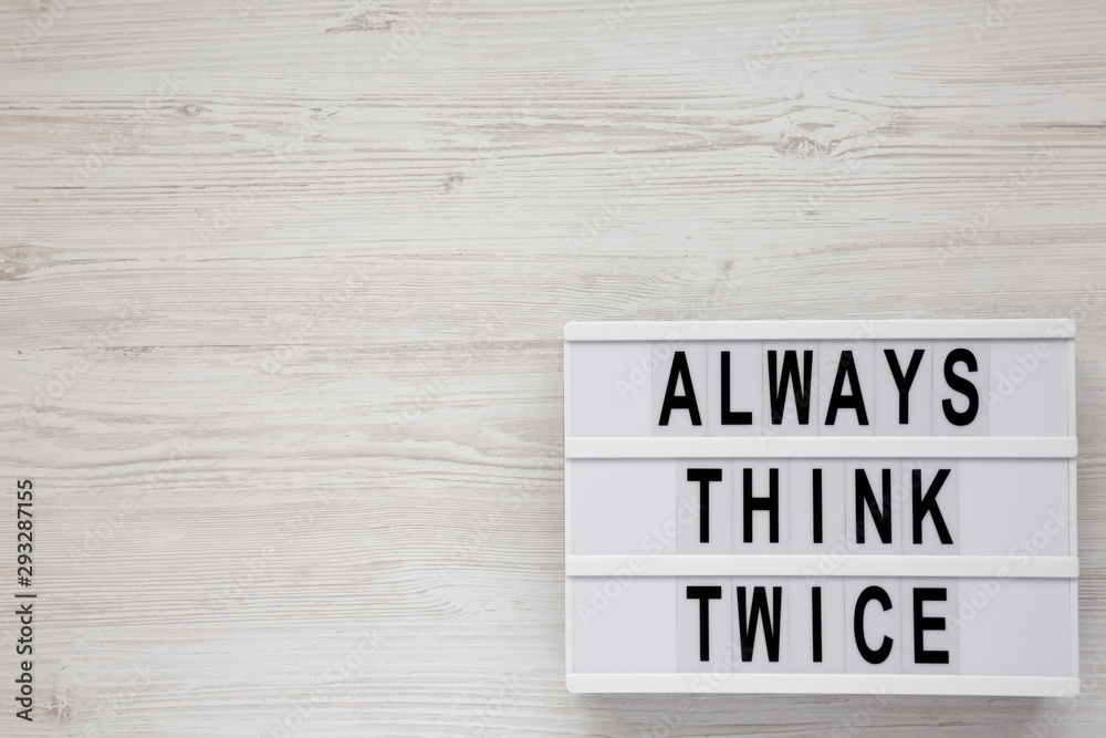 'Always think twice' words on a modern board on a white wooden background, top view. Overhead, from above, flat lay. Copy space. 'Always think twice' words on a modern board on a white wooden background, top view. Overhead, from above, flat lay. Copy space.