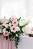 Beautiful flowers of light pastel shades on the table of the groom and bride