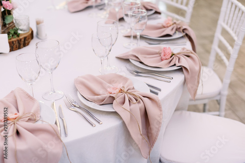 Luxurious wedding table decoration for reception of guests with stylish napkins, cute natural flower