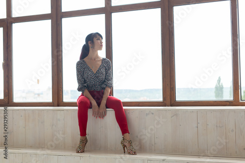 Beautiful pretty slim woman sitting by the window