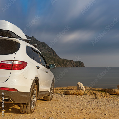 A large white car in front of the sea. photo