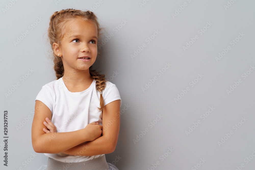 Beautiful little girl posing over a grey background. Beautiful little girl posing over a grey background.