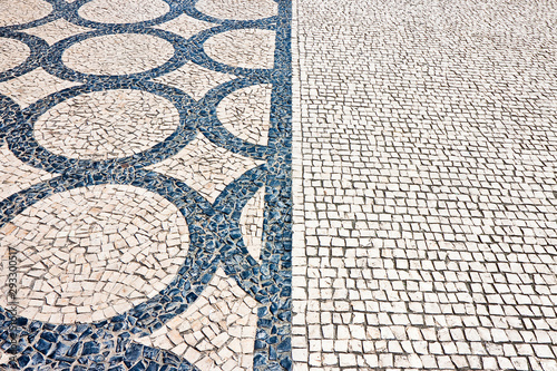 Typical portuguese floor made of small pieces of black and white stone in shape of circles and arcs (Portugal - Europe)