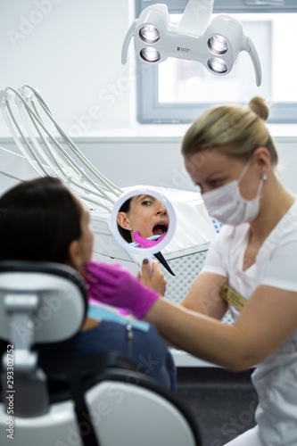 Young doctor conducts oral hygiene to a patient