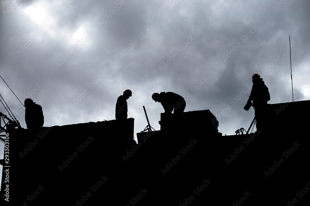 Construction site. Workers silhouette during development of the biulding