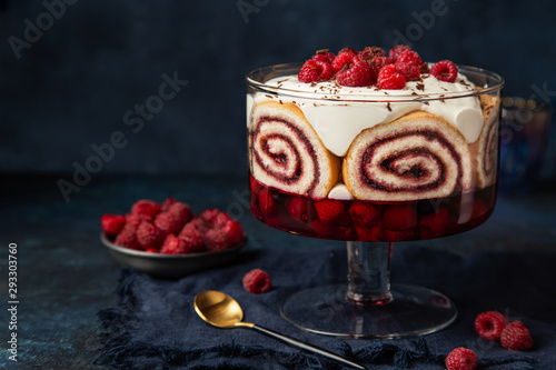 Trifle. Festive layered dessert with berry jelly, swiss roll cake and whipped cream