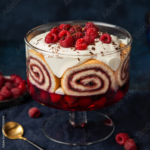 Raspberry trifle with berry jelly, swiss roll cake and whipped cream