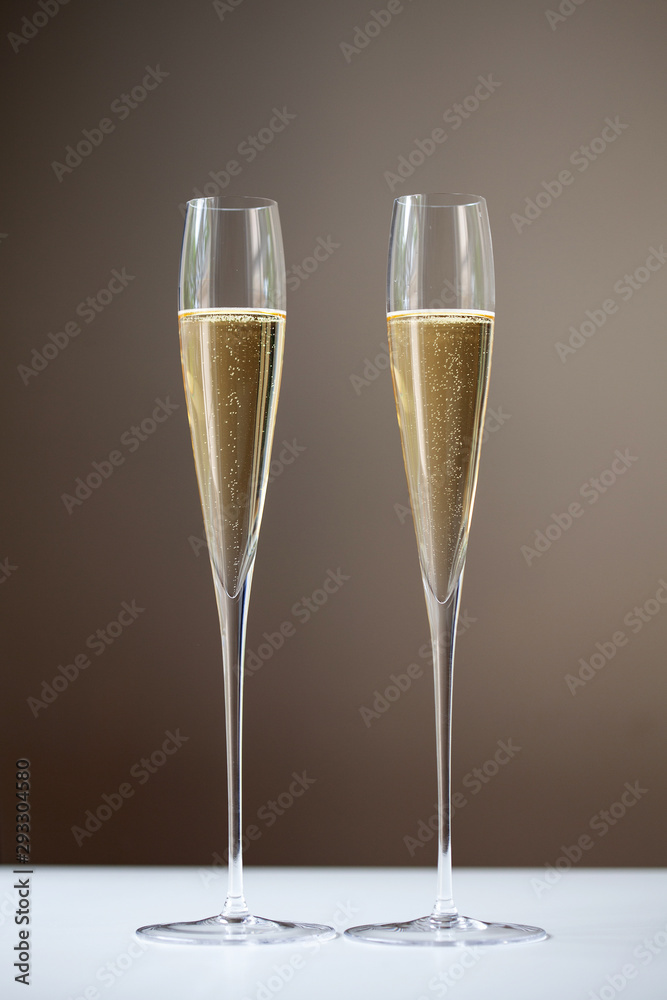 Two tall champagne flutes containing sparkling wine Two tall champagne flutes containing sparkling wine