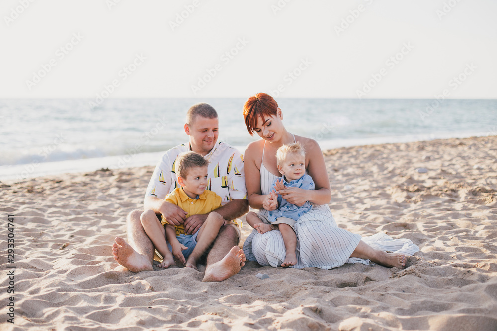 Happy family having fun on beach at sunset Happy family having fun on beach at sunset