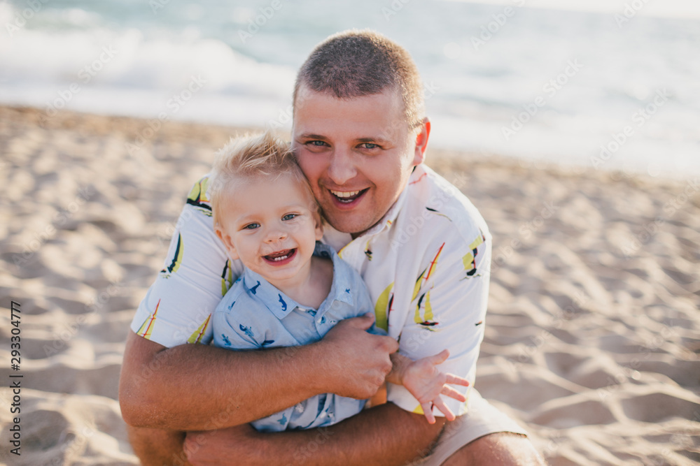 Father having fun with son on beach at sunset Father having fun with son on beach at sunset