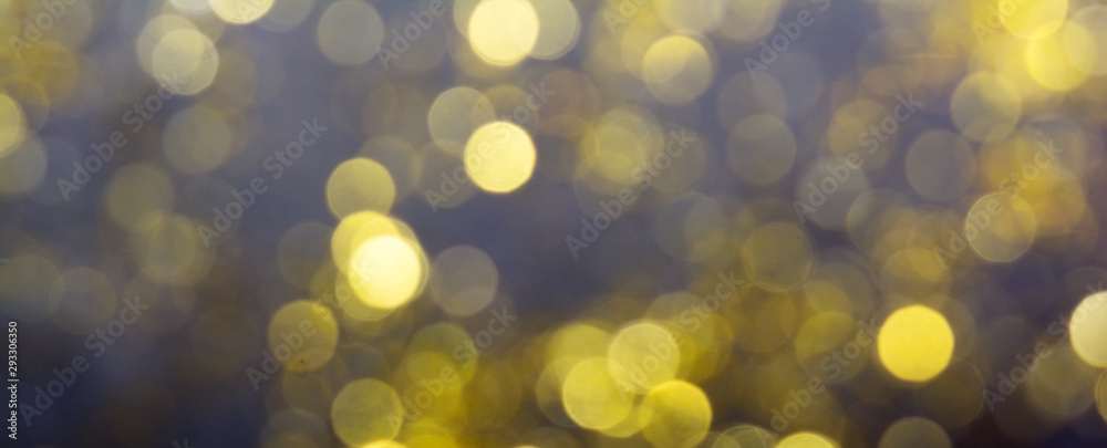 Abstract blurred glitter bokeh background in gold, on black