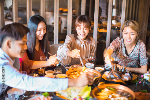 Happy friends having fun in hot pot restaurant