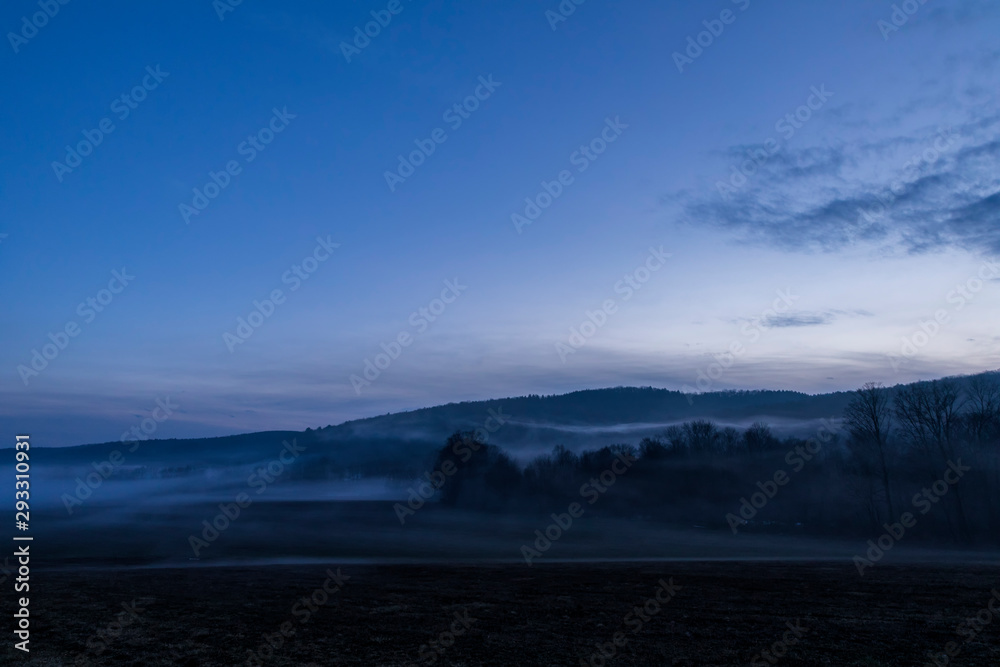 A ghostly fog hovers over farmland along a country road in New York State during a warm January evening. A ghostly fog hovers over farmland along a country road in New York State during a warm January evening.
