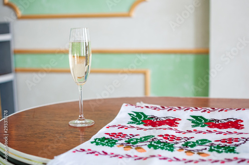 a glass of champagne and an embroidered towel stands on the table photo