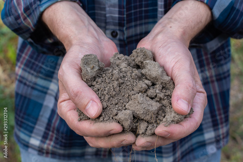 Farmer hands with soil in the palms close-up , man hands with fertile soil