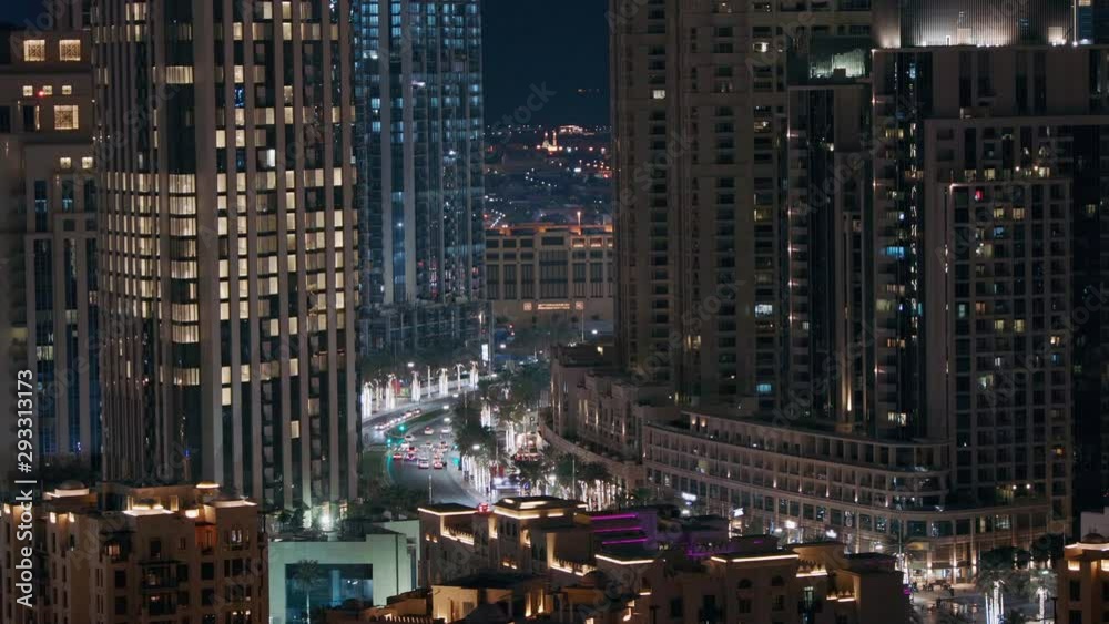 Intersection traffic at night on Mohammed Bin Rashid Boulevard curves among the many illuminated skyscrapers and towers that comprise the Dubai city skyline. Intersection traffic at night on Mohammed Bin Rashid Boulevard curves among the many illuminated skyscrapers and towers that comprise the Dubai city skyline.