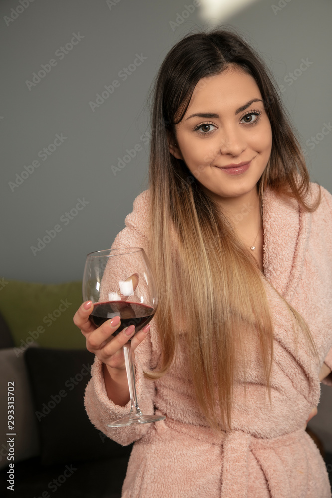young girl in a bathrobe drinks wine in the morning young girl in a bathrobe drinks wine in the morning