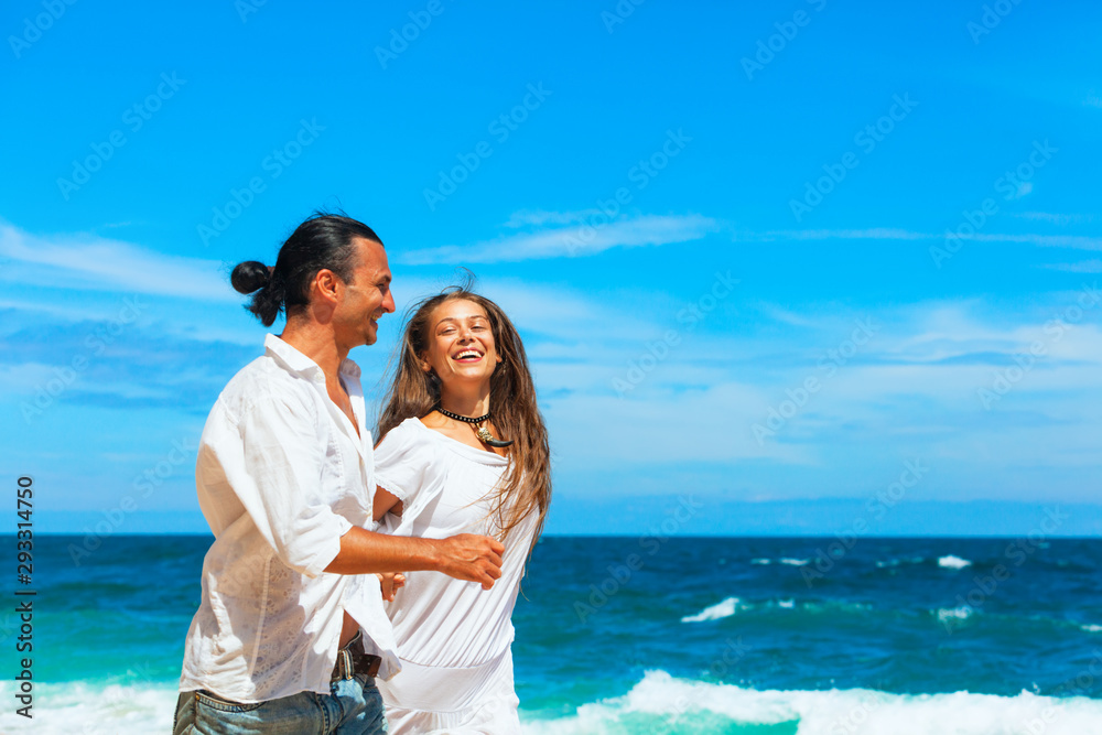 Happy family on honeymoon holiday - just married young couple having fun, run by water edge along sea beach surf. Active lifestyle, people recreational activity on summer vacation on tropical island. Happy family on honeymoon holiday - just married young couple having fun, run by water edge along sea beach surf. Active lifestyle, people recreational activity on summer vacation on tropical island.