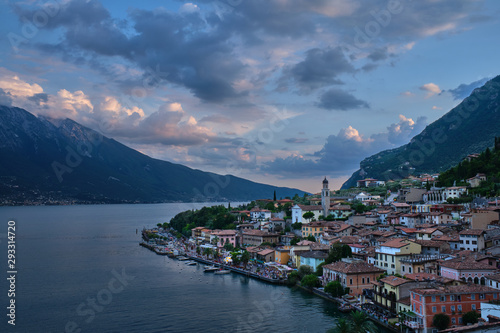 Panoramic view of night city Limone Sul Garda region Trento Lake Garda Italy. A popular resort town. Summer time of the year. Aerial view. City night lanterns, reflection of lamps.