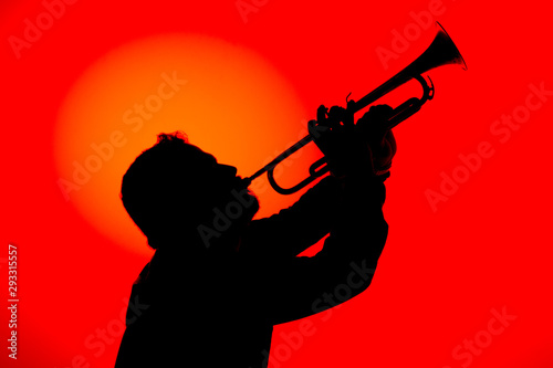 Silhouette of a jazz musician  playing trumpet  isolated in red background. Jazz music concept.