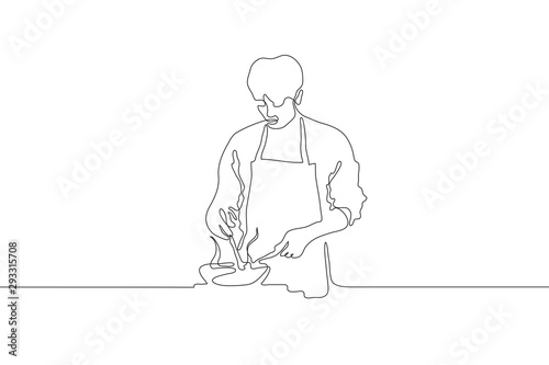 Continuous line drawing of a male cook in an apron holding a spoon which interferes with food in the pan. A man stands the stove and cooks. It can be used for animation. Vector