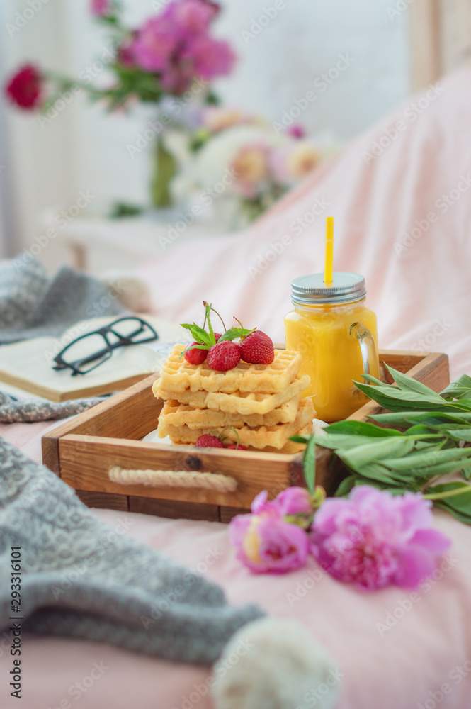 Waffles with strawberries on wood board and tulips