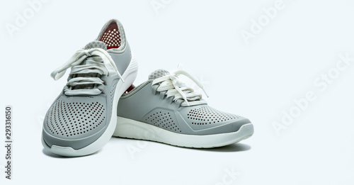 A pair of grey shoes on white background. Comfortable shoes with pore. Breathable rubber shoes. Footwear. photo