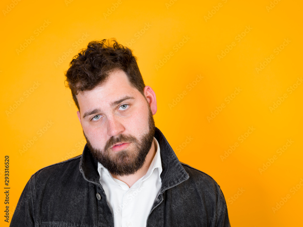 Fototapeta premium one cool man with black beard and black hair is posing in front of orange background