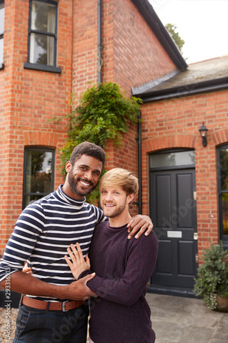 Portrait Of Excited Gay Male Couple Standing Outside New Home On Moving Day Together © Monkey Business