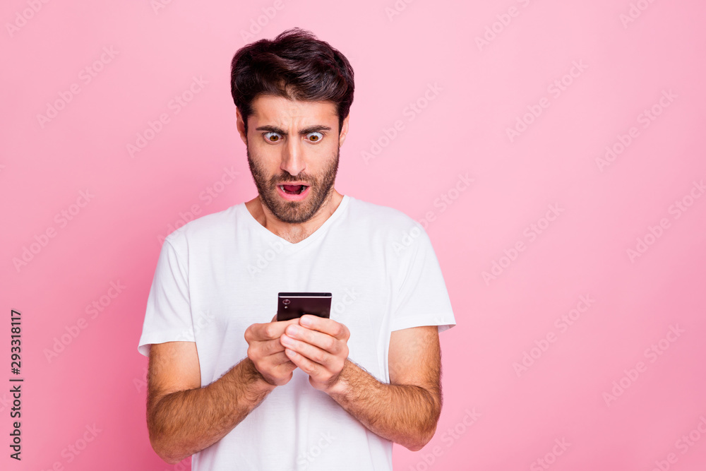 Portrait of impressed amazed emotion middle eastern man use his smartphone look read feedback feednews comments scream wow omg wear style summer outfit isolated over pink color background Portrait of impressed amazed emotion middle eastern man use his smartphone look read feedback feednews comments scream wow omg wear style summer outfit isolated over pink color background