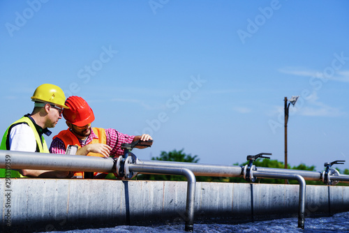 Engineers controlling a quality of water ,aerated activated sludge tank at a waste water treatment plant   