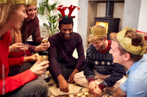 Group Of Friends Playing Board Games After Enjoying Christmas Dinner At Home photo