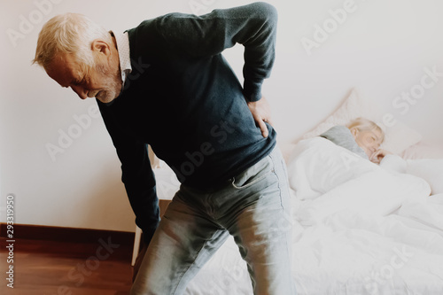 Old man with back ache clasping . Man suffering from ribbing pain or waist pain.