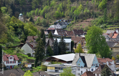 Cute village in Germany on a hillside, apartment buildings on the background of the forest. Spring in a German village