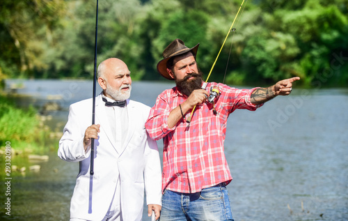 Hobby and recreation. Family day. Summer vacation. Fishing as holiday. Fisherman in formal suit. Successful catch. Friends fishing. Elegant bearded man and brutal hipster fishing. Perfect weekend