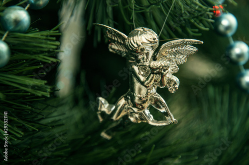 Close up, macro. A fragment of a Christmas tree, silver angel decoration.