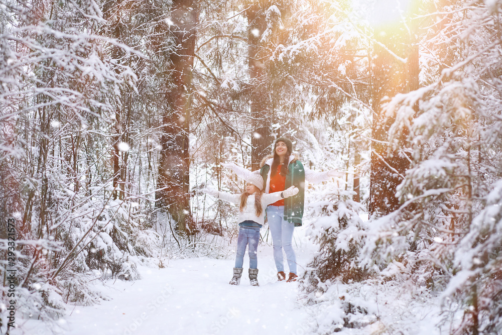 Young family for a walk. Mom and daughter are walking in a winter park. Young family for a walk. Mom and daughter are walking in a winter park.